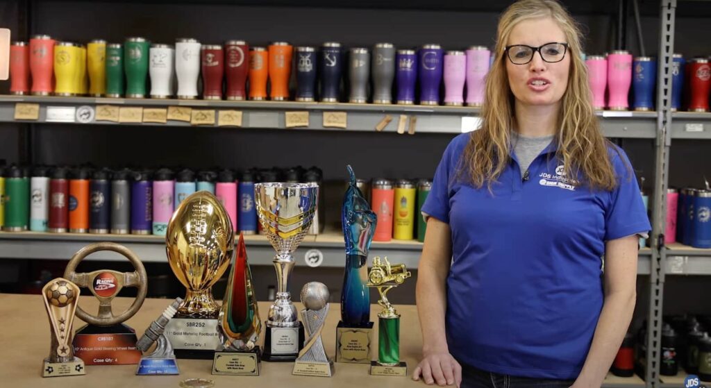 Woman standing next to trophies